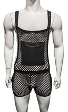 Load image into Gallery viewer, Mannequin wearing overalls made from a black fishnet fabric, featuring a solid square pocket with a zipper seal. The shoulder straps are held with large buttons, and can be adjusted