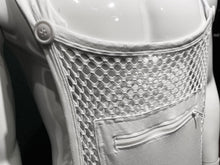Load image into Gallery viewer, Close up view of white fishnet overalls featuring the buttons for the shoulder straps and the zipper-sealed kangaroo pocket