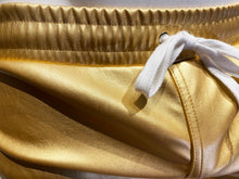 Load image into Gallery viewer, Close up of waistband of gold faux leather shorts with side pockets and a white string waistband