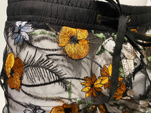 Load image into Gallery viewer, A pair of black and orange floral mesh shorts with side pockets and a drawstring waistband displayed on a mannequin - close up on waistband