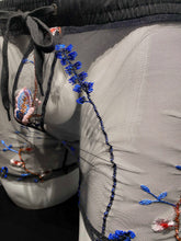 Load image into Gallery viewer, Off angle close up view of black blue embroidered floral mesh shorts, showing the embroidery