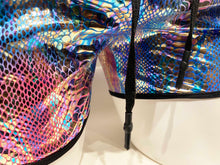Load image into Gallery viewer, Close view of the lower part of the shorts, showing drawstring and black hem, as well as the reflective metallic snake print fabric