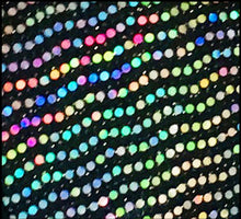 Load image into Gallery viewer, Close up view of multicolor reflective sequins on black fabric