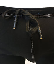 Load image into Gallery viewer, Close up view of black drawstring waistband of black cotton shorts with rainbow stripes down either side of the front