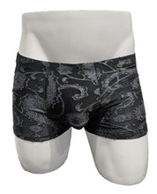 Load image into Gallery viewer, Black trunks with silver floral paisley embroidery on a white mannequin
