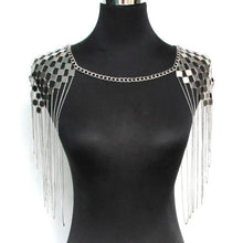 Load image into Gallery viewer, Black mannequin wearing a decorative shoulder piece. Shoulder piece is a silver chain necklace attached to checkered shoulder decoration with fringe details
