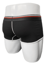 Load image into Gallery viewer, Rear view of mannequin wearing black trunks. Waistband is black elastic with a white and red stripe

