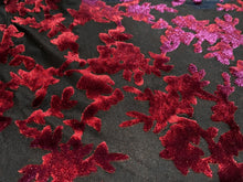 Load image into Gallery viewer, Close up view of black mesh fabric with red floral/leafy velvet embellishments
