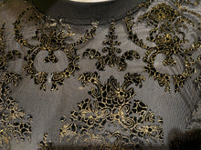 Load image into Gallery viewer, Close-up of a black sheer mesh fabric with ornate black and gold gold flocked floral embellishment.
