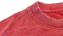Load image into Gallery viewer, Close-up of a red mineral-washed cotton t-shirt showing the ribbed crew neck collar and textured fabric against a white background.
