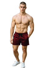 Load image into Gallery viewer, Man wearing maroon velvet shorts with pockets and a drawstring
