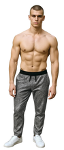 Load image into Gallery viewer, Man wearing black pants with silver sequins and black drawstring and white sneakers on a white background
