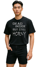 Load image into Gallery viewer, Person wearing a black t-shirt with text &#39;DEAD INSIDE BUT STILL HORNY&#39; 

