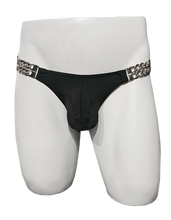 Load image into Gallery viewer, Black swim brief held by silver chains on left and right sides
