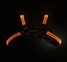 Load image into Gallery viewer, Black harness with orange light strips on a black background
