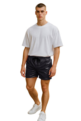 Man wearing a white t-shirt and shiny black shorts on a white background