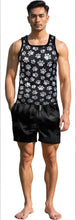 Load image into Gallery viewer, Man wearing a black tank top with white puppy paw print pattern and black shorts
