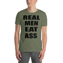 Load image into Gallery viewer, Person wearing an army green t-shirt with black &#39;REAL MEN EAT ASS&#39; text.
