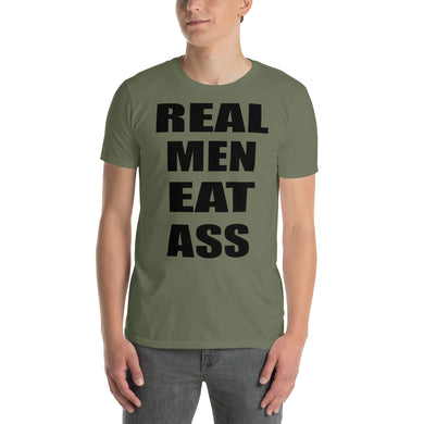 Person wearing an army green t-shirt with black 'REAL MEN EAT ASS' text.