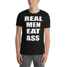 Load image into Gallery viewer, Person wearing a black t-shirt with white text &#39;REAL MEN EAT ASS&#39;
