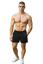 Load image into Gallery viewer, Man wearing black velvet shorts with pockets and a drawstring waistband
