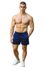Load image into Gallery viewer, Man wearing blue velvet shorts with pockets and a drawstring waistband
