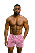 Load image into Gallery viewer, Man wearing pink velvet shorts with a drawstring and pockets 
